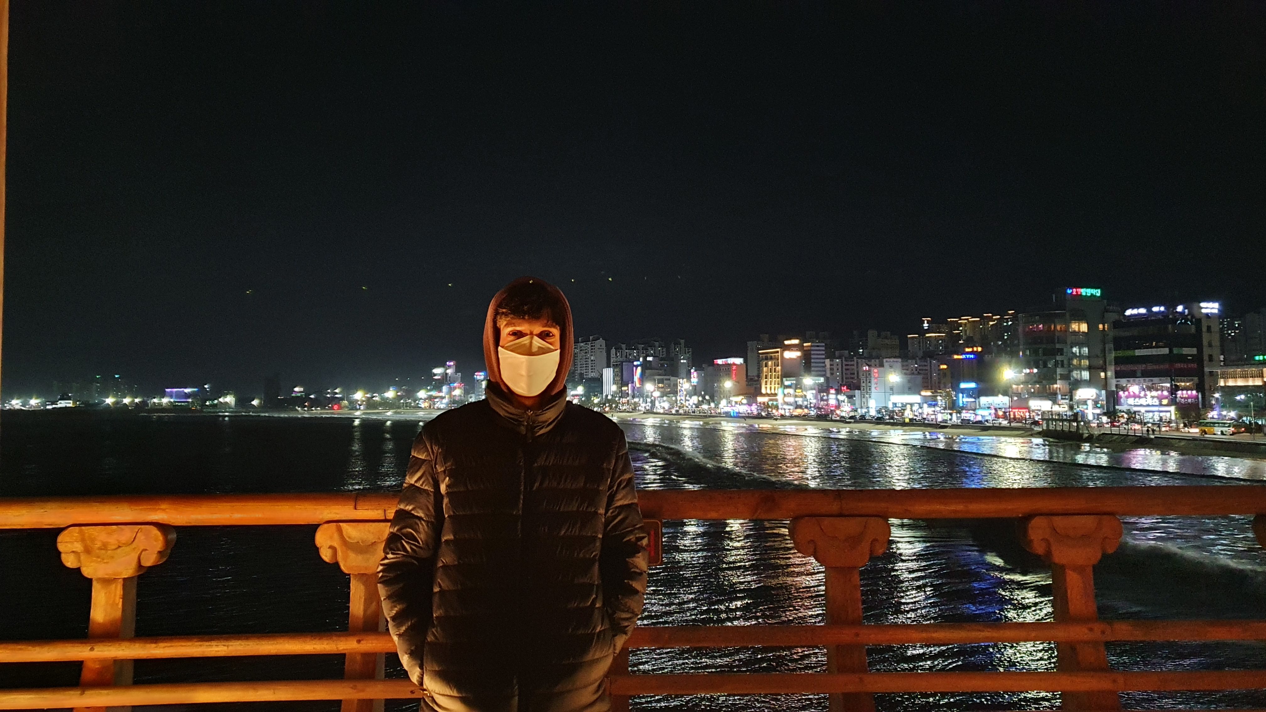 Night view of beach city with man in foreground