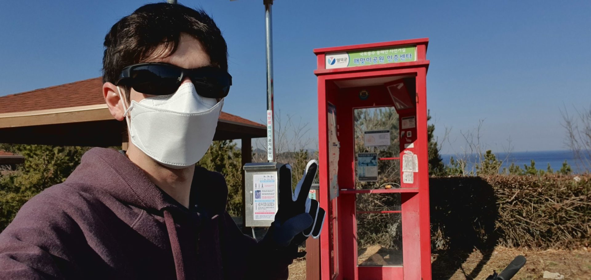 Man in mask and sunglasses at stamp booth on Korea East Coast Bike Path